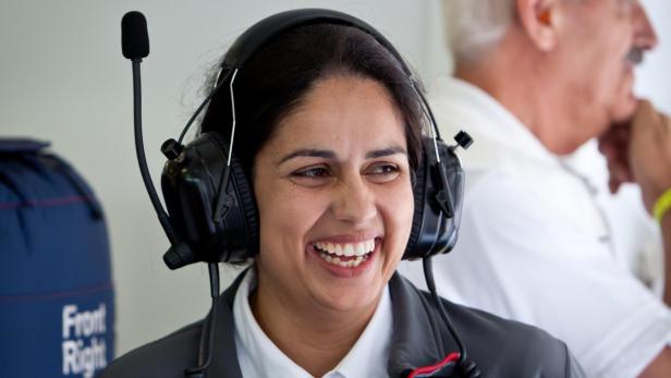 Eine lächelnde Frau trägt ein Headset mit Mikrofon.