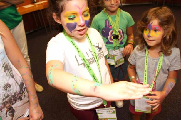 Mehrere Kinder mit Gesichtsbemalung stehen zusammen.
