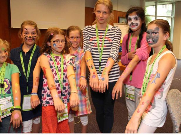 Eine Gruppe Mädchen mit Gesichtsbemalung und Armbemalung posiert für ein Foto.