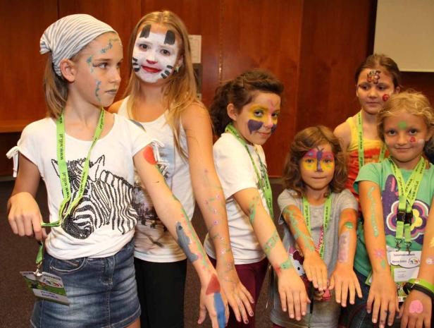 Eine Gruppe von Mädchen mit bemalten Gesichtern und Armen posiert für ein Foto.