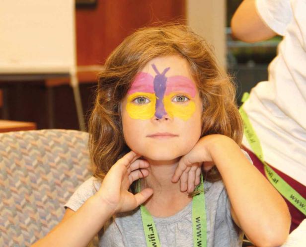 Ein Mädchen mit einem Schmetterling auf dem Gesicht.