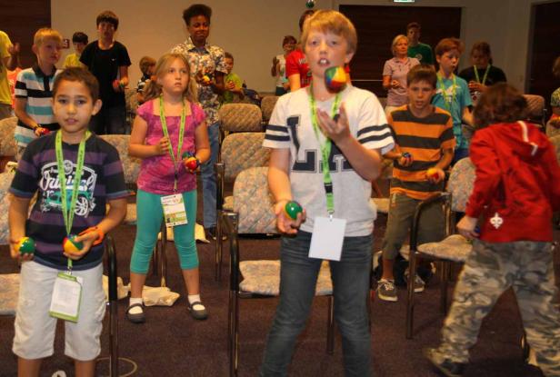 Eine Gruppe von Kindern übt Jonglieren mit bunten Bällen.
