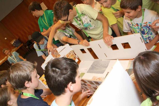 Eine Gruppe von Kindern arbeitet an einem Modellhaus.