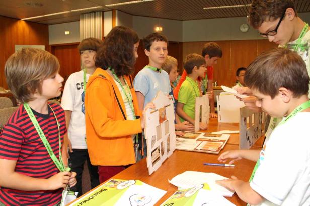 Eine Gruppe Kinder arbeitet an einem Tisch an einem Projekt.