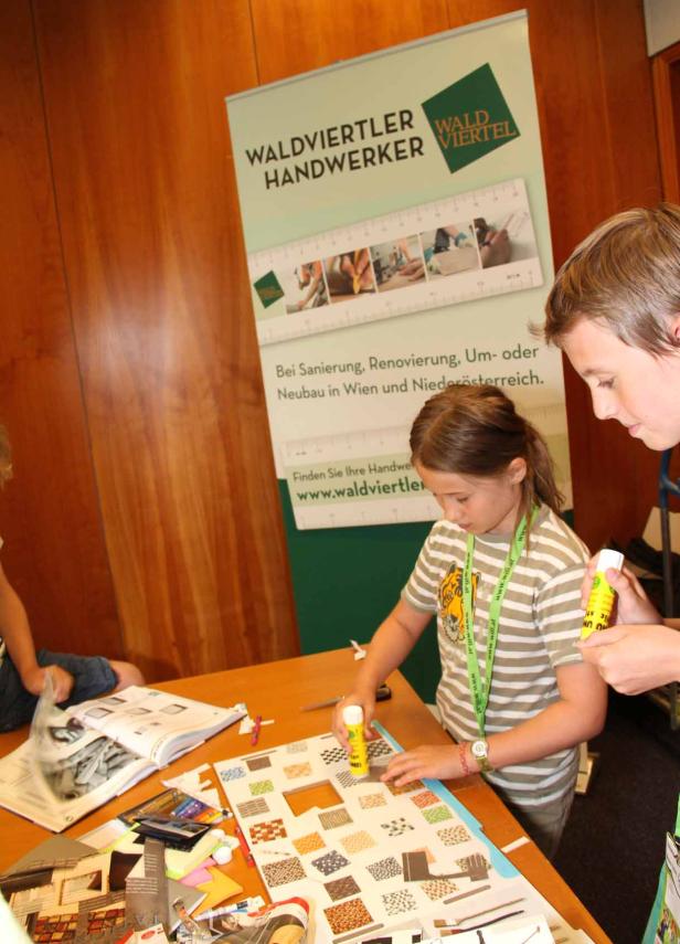 Kinder basteln an einem Tisch mit Materialien der Waldviertler Handwerker.