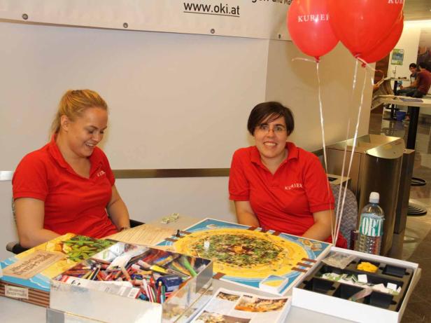 Zwei Frauen sitzen an einem Tisch mit dem Brettspiel „Abenteuer Bergbau“.