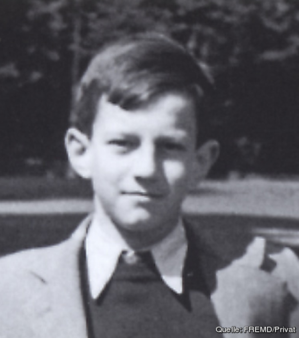 Ein junger Mann in Jacke und Hemd blickt in die Kamera.