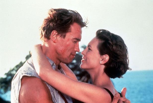 Arnold Schwarzenegger und Jamie Lee Curtis umarmen sich in einer Szene aus „True Lies“.