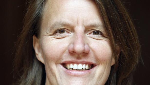 Das Gesicht einer lächelnden Frau mit braunen Augen und braunem Haar.