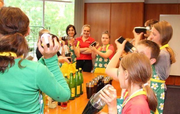 Eine Gruppe von Kindern mixt Cocktails in einem Workshop.