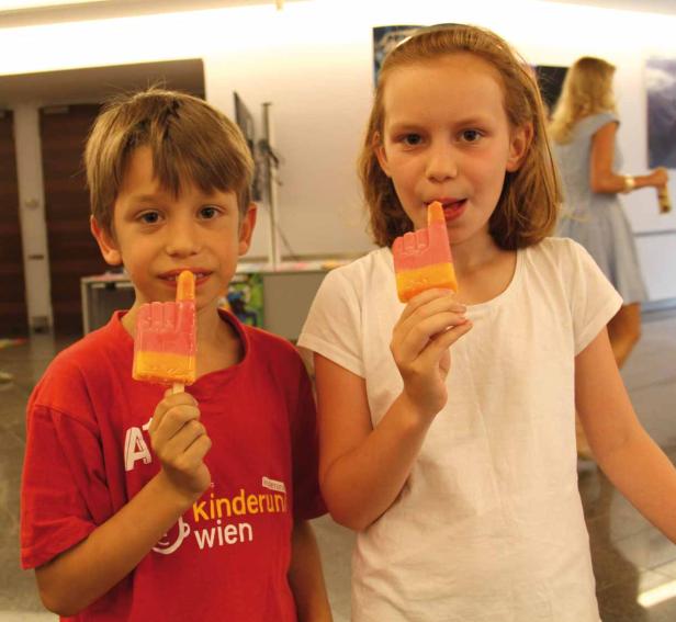 Ein Junge und ein Mädchen essen ein Eis in Form einer Hand.