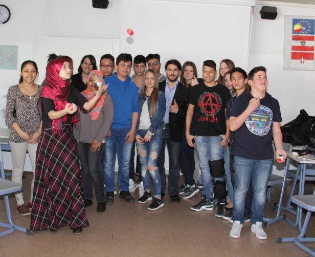 Eine Frau jongliert mit Bällen vor einer Gruppe von Schülern in einem Klassenzimmer.