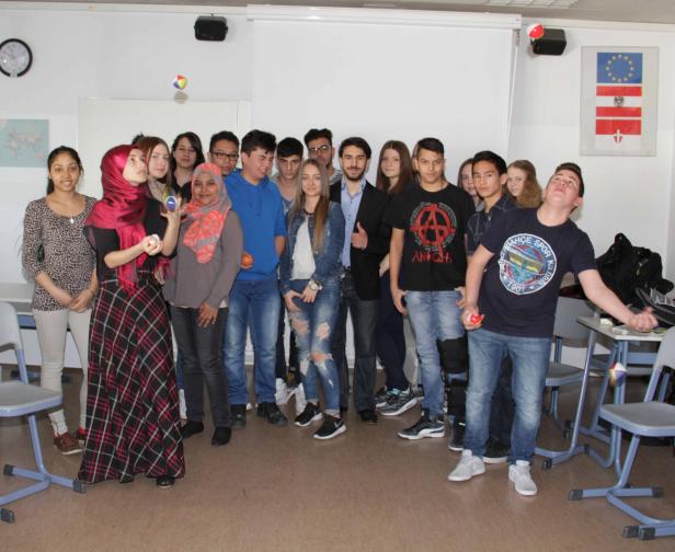 Eine Gruppe von Studenten steht in einem Klassenzimmer und jongliert mit Bällen.