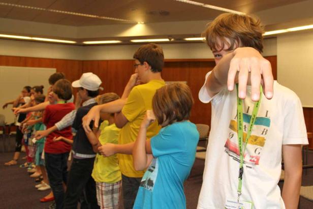 Eine Gruppe von Kindern steht in einer Reihe und macht Dehnübungen.