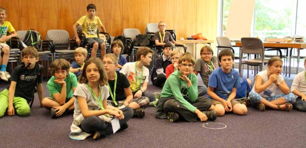 Eine Gruppe von Kindern sitzt auf dem Boden in einem Raum.