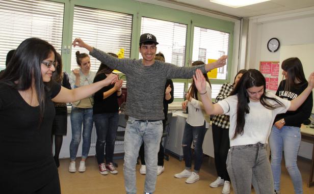 Eine Gruppe junger Leute tanzt in einem Raum.