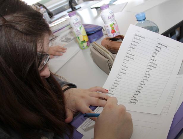 Eine Frau füllt eine Liste mit Namen und deren Übersetzung in eine andere Sprache aus.