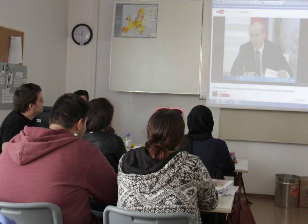Schüler schauen in einem Klassenzimmer ein Video von Putin an.