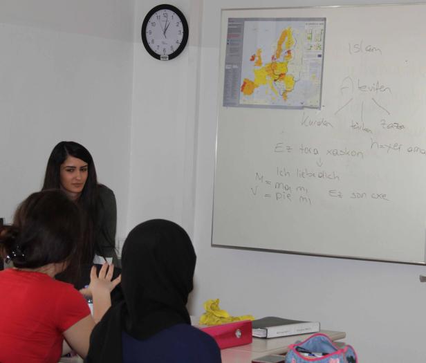 In einem Klassenzimmer diskutieren Schüler vor einer Tafel über das Thema Islam.