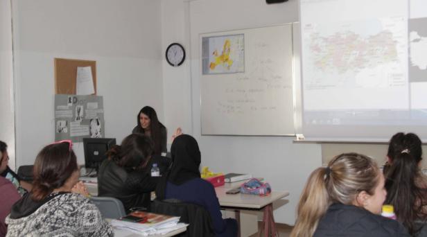 Eine Lehrerin unterrichtet eine Klasse mit Schülerinnen in einem Klassenzimmer.