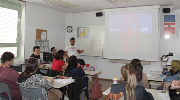 Ein Lehrer präsentiert Roma und Sinti vor einer Klasse in Österreich.