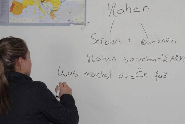 Eine Frau schreibt mit einem Stift auf ein Whiteboard mit Notizen über Vlachen, Serbien und Rumänien.
