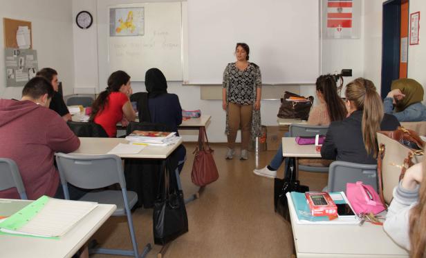 Eine Lehrerin hält vor einer Klasse einen Vortrag.