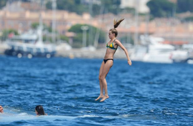 Eine Frau springt mit einem Bikini ins Meer.