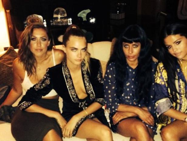 Cara Delevingne und Selena Gomez mit zwei weiteren Frauen auf einem Sofa.