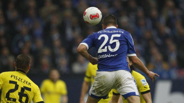 Ein Fußballspieler von Schalke 04 köpft den Ball.