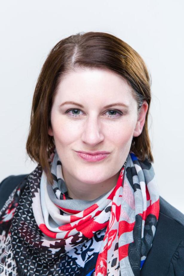 Porträt einer Frau mit braunen Haaren und einem bunten Schal.