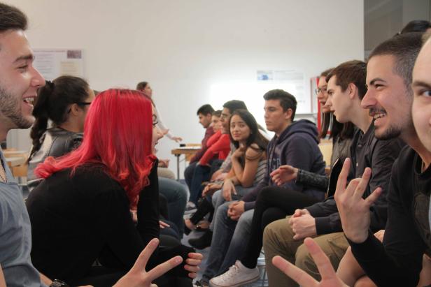 Eine Gruppe junger Leute sitzt im Kreis und unterhält sich angeregt.