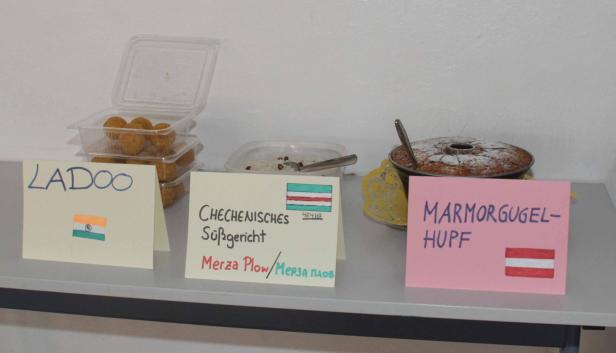 Auf einem Tisch stehen Süßspeisen aus Indien, Tschetschenien und Österreich.