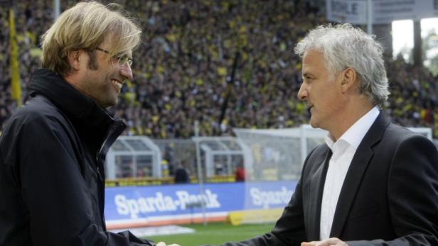 Jürgen Klopp begrüßt einen Kollegen auf dem Fußballfeld.