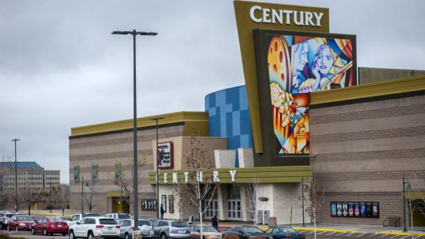 Das Century Kino mit seinem markanten Schild und dem belebten Parkplatz.