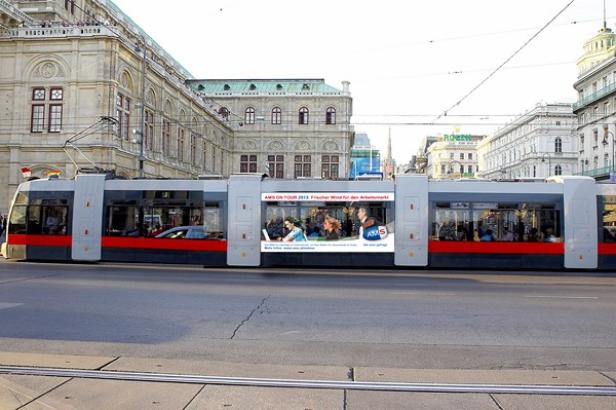 Eine Straßenbahn fährt vor der Wiener Staatsoper entlang.