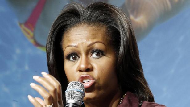 Michelle Obama spricht bei einer Veranstaltung in ein Mikrofon.