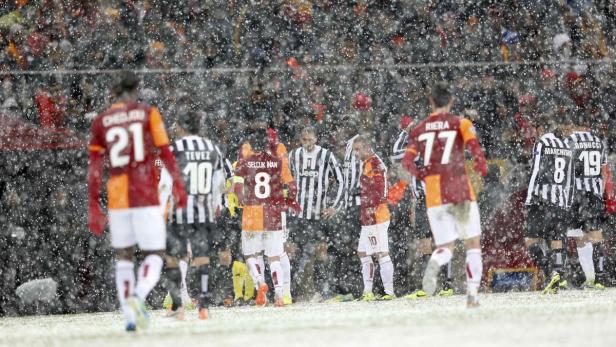 Fußballspieler während eines Schneefalls auf dem Spielfeld.