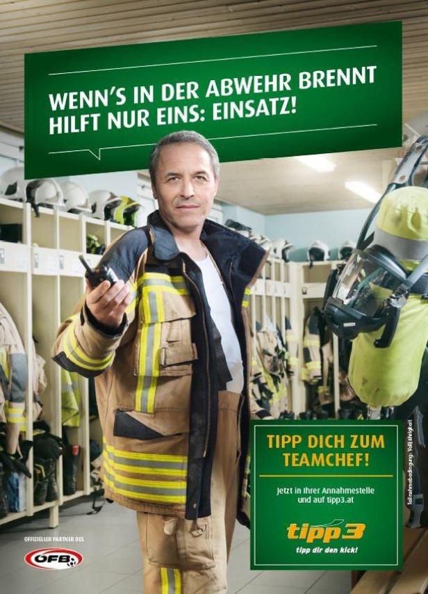 Ein Feuerwehrmann in Einsatzkleidung hält ein Funkgerät in der Hand.