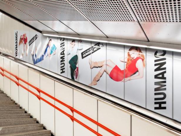 U-Bahn - Wien Eine Treppe in einer U-Bahnstation mit Werbung für „HUMANIC“.