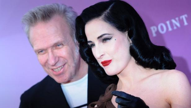 EPAepa03206272 Jean Paul Gaultier (L) and Dita Von Teese arrive at the Tempodrom for the German Fragrance Prize Duftstars in Berlin, Germany, 04 May 2012. The prize is the most important award for the perfume industry. EPA/BRITTA PEDERSEN Dita Von Teese mit einem Mann auf einer Veranstaltung vor einem lila Hintergrund.