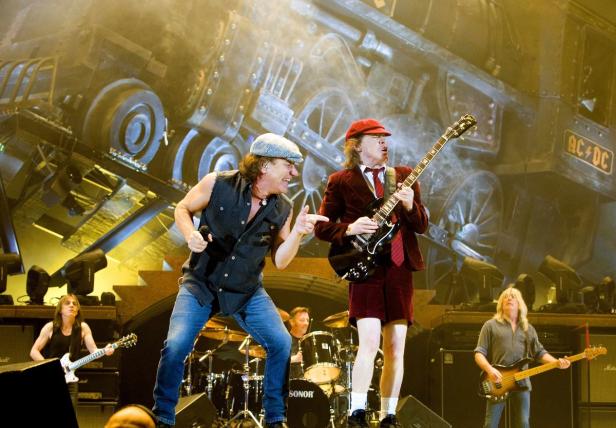 AC/DC tritt vor einer Bühnenkulisse mit einem riesigen Zug auf.