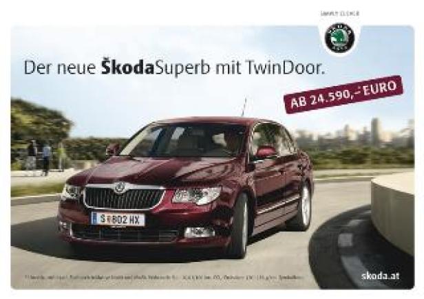 Cayenne/Skoda Superb 2 Ein roter Škoda Superb fährt auf einer Straße vor einer Stadtkulisse.