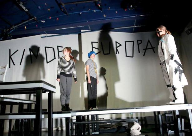 Drei Schauspieler stehen auf einer Bühne vor dem Schriftzug „Kinder Europas“.
