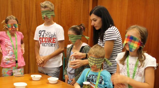 Eine Gruppe Kinder nimmt an einem Geschmacks-Test mit verbundenen Augen teil.