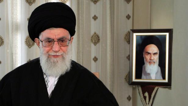 Ali Khamenei posiert vor einem Porträt von Ruhollah Chomeini.