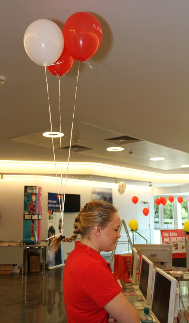 Eine Frau steht in einem Raum mit Ballons und Computern.