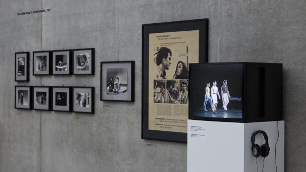 Eine Ausstellung mit Fotos, einem Poster von Yvonne Rainer und einer Videoinstallation.