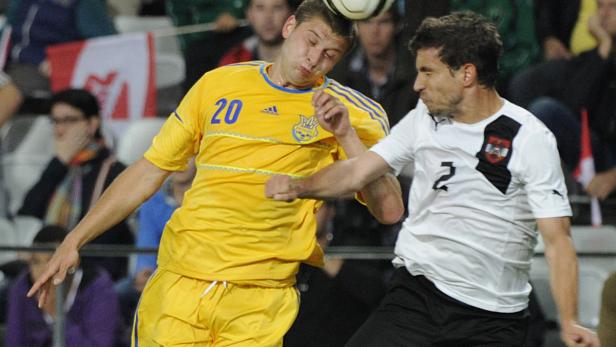 Zwei Fußballspieler kämpfen um den Ball während eines Spiels.