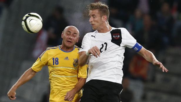 Zwei Fußballspieler kämpfen um den Ball während eines Spiels.